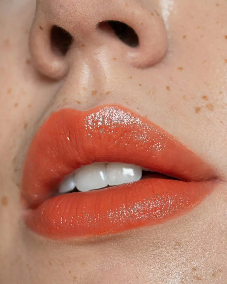Vibrant summer orange lip with glossy finish.