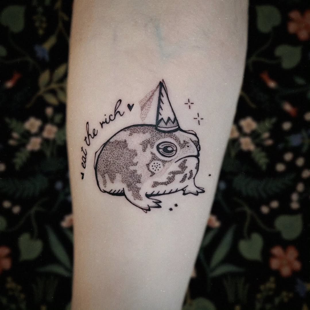 Whimsical frog tattoo with a party hat