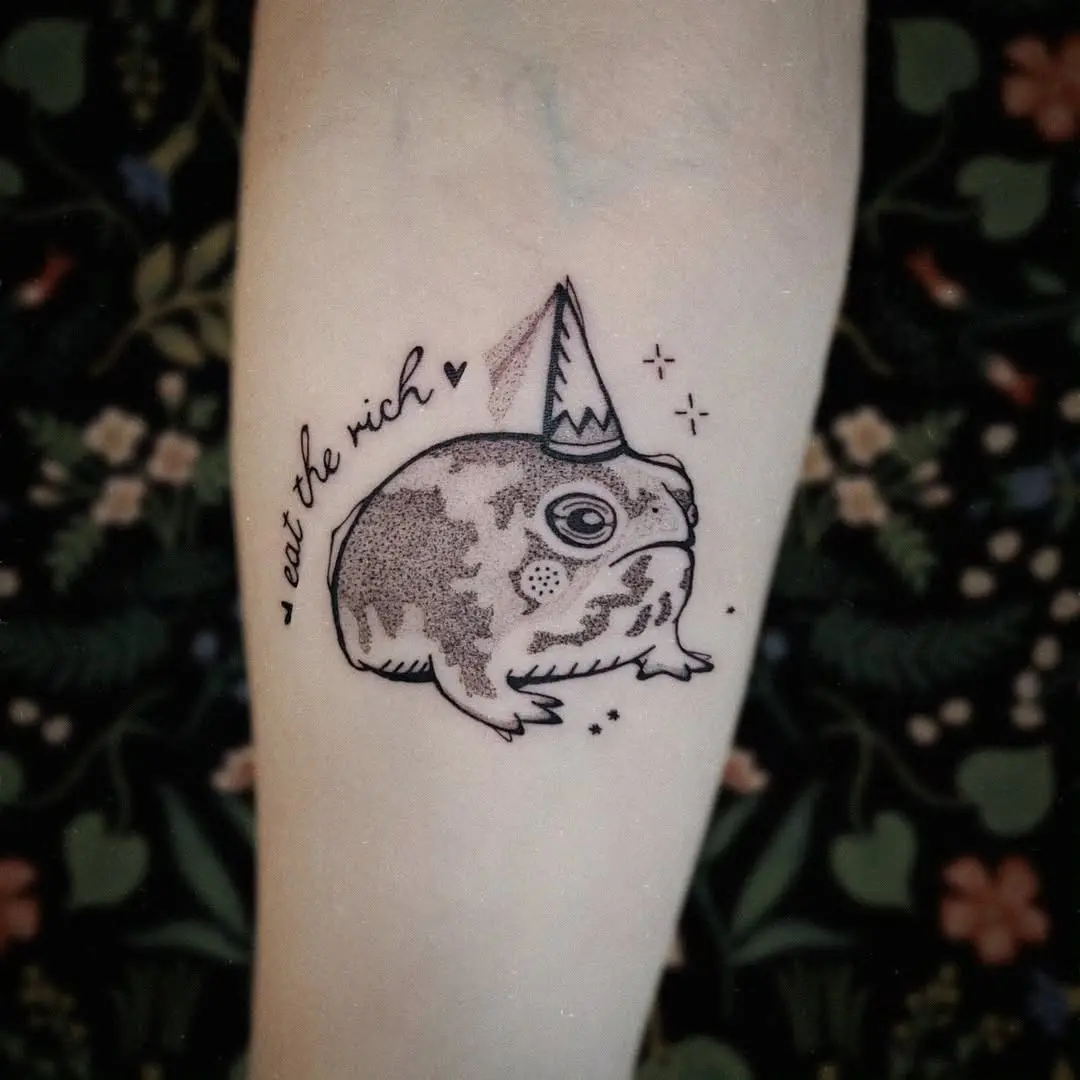 Whimsical frog tattoo with a party hat