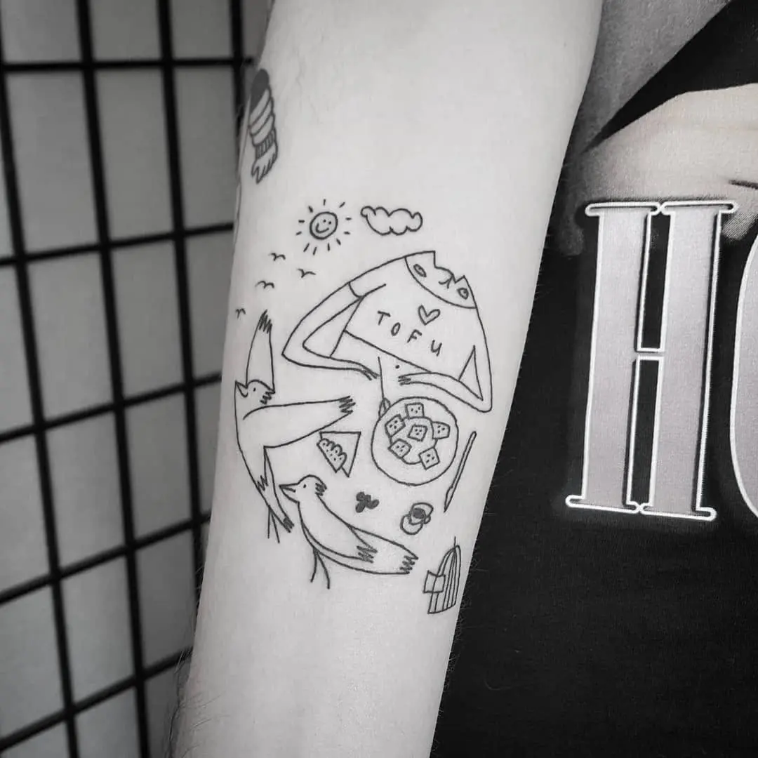 Playful vegan-themed tattoo with birds and tofu