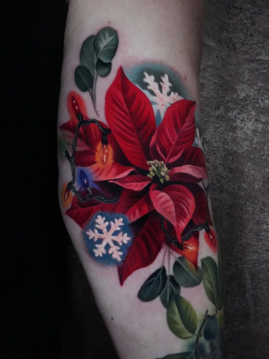 Vibrant poinsettia tattoo with festive details
