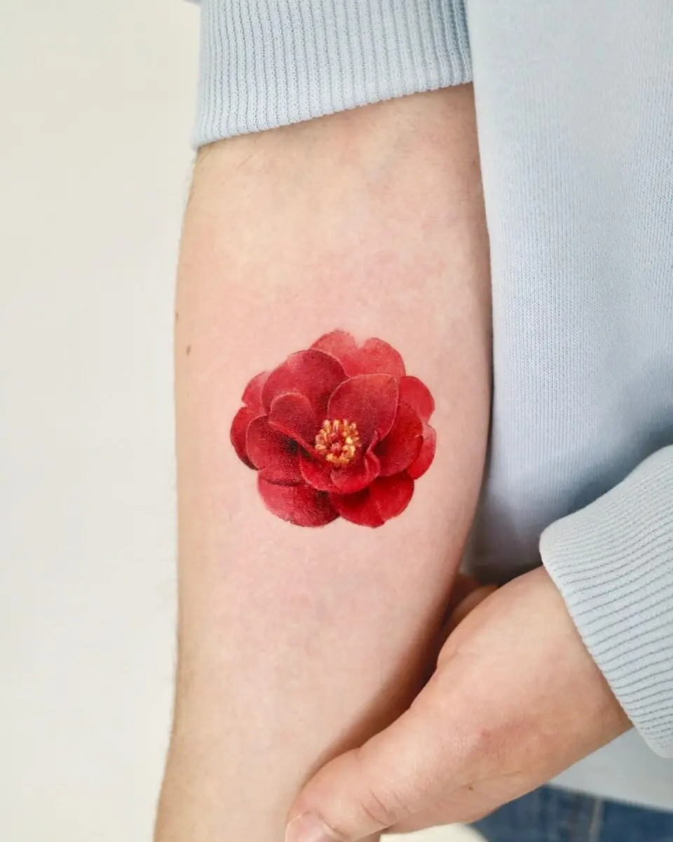 Stunning red camellia tattoo on forearm