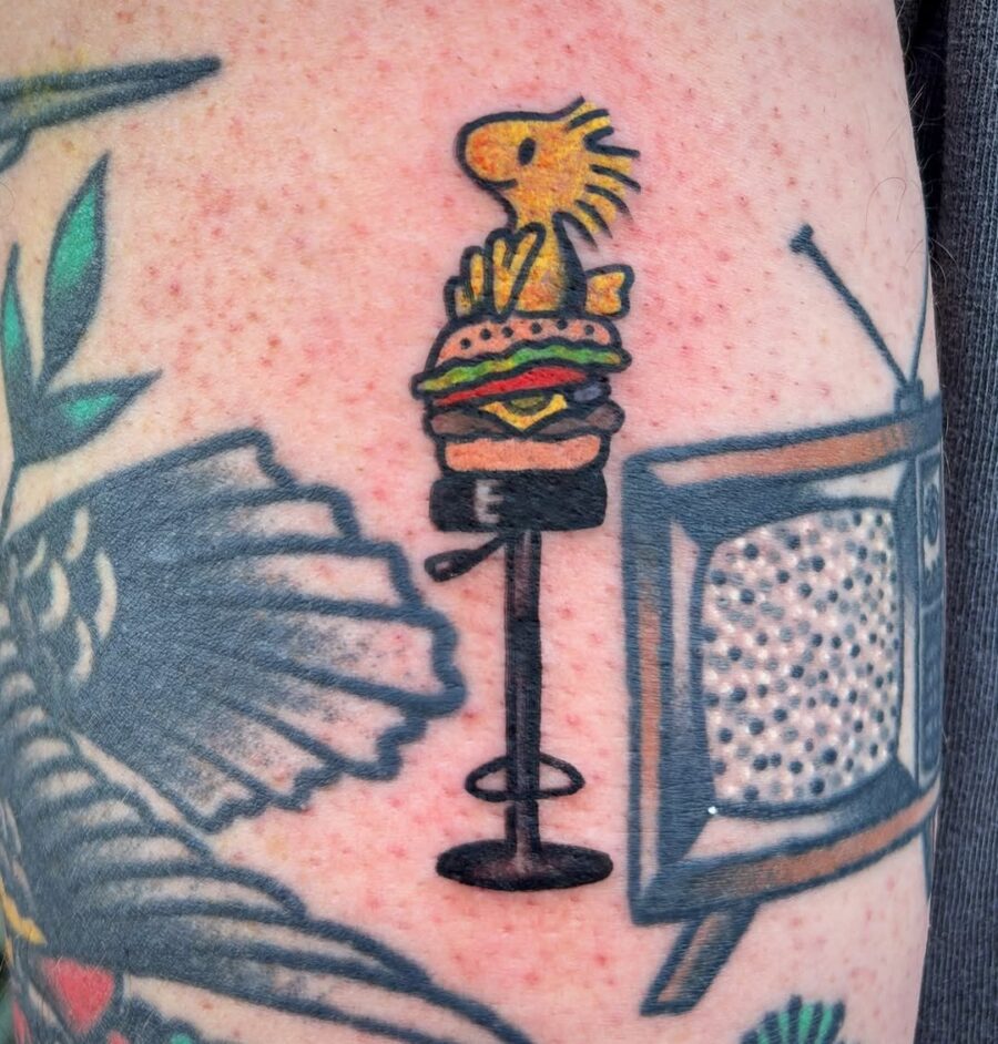 A playful burger tattoo with a cute character