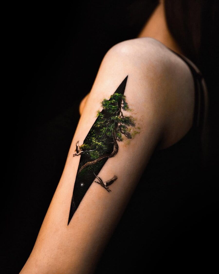 Intricate forest scene tattoo on the arm