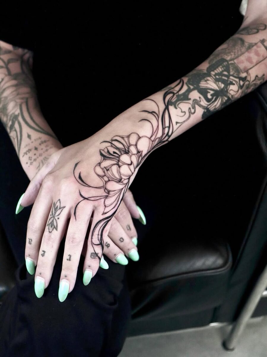 Elegant floral hand tattoo with bold outlines
