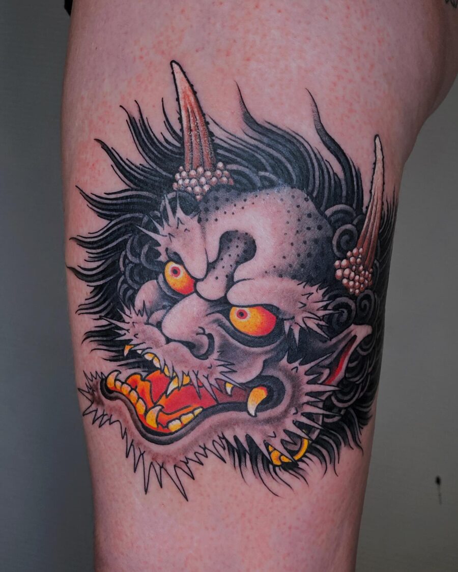 Intense demon face tattoo with vivid colors.