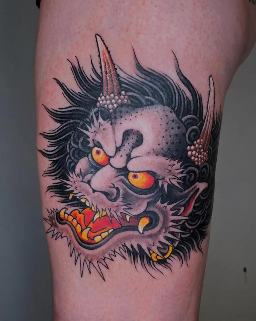 Intense demon face tattoo with vivid colors.