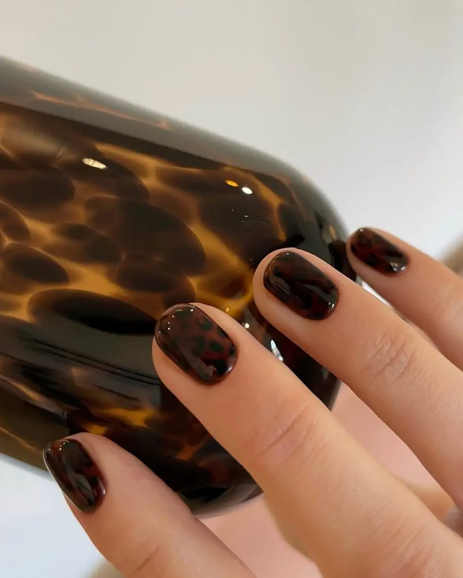 Glossy animal print nails with dark hues