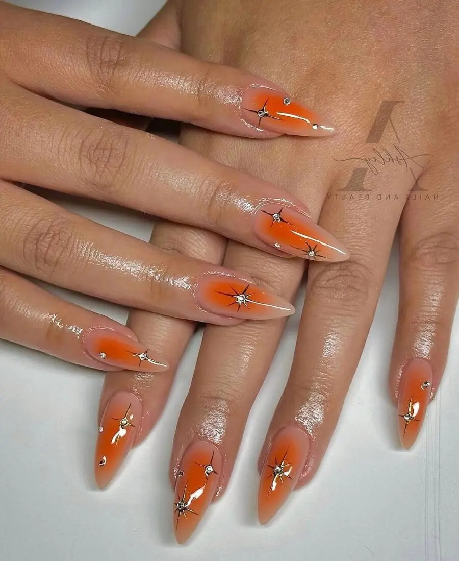 Vibrant orange aura nails with star accents
