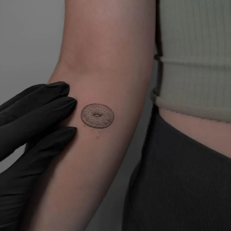 Delightfully realistic bagel tattoo on arm
