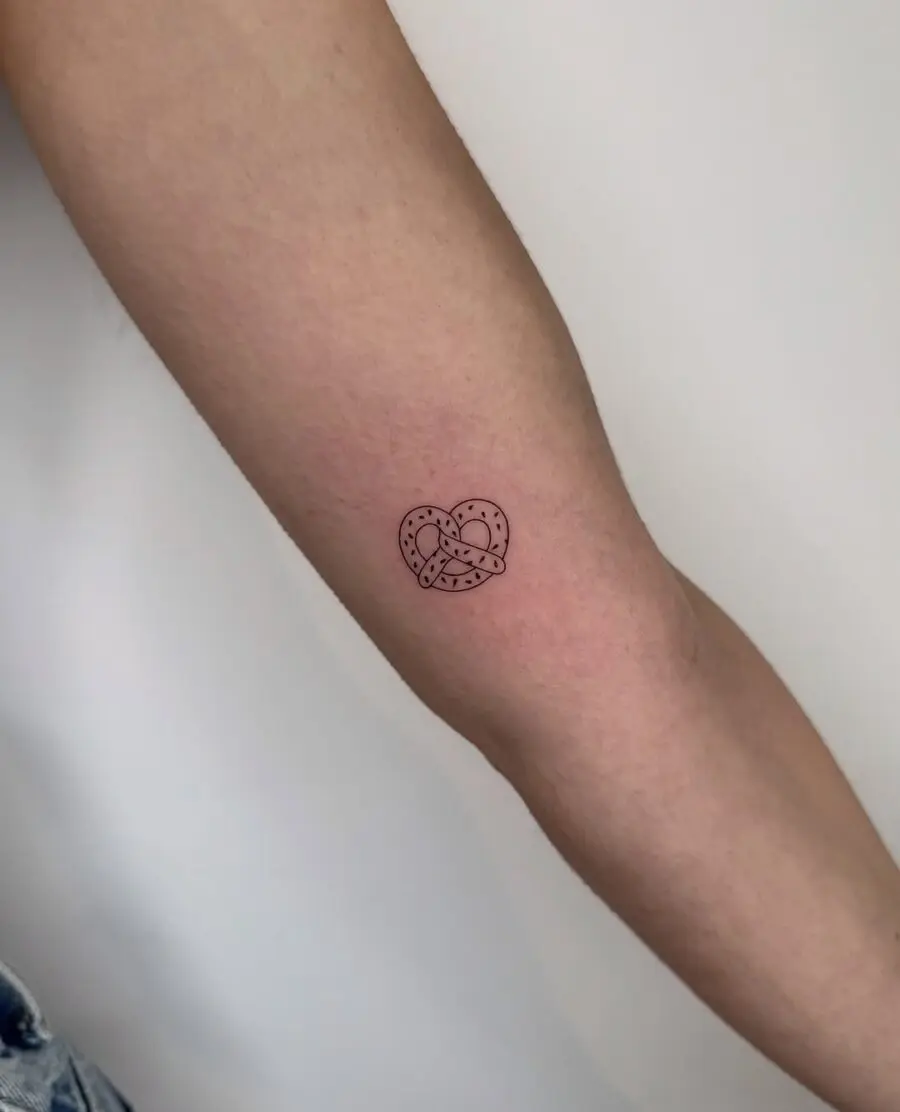 Charming pretzel heart tattoo on forearm