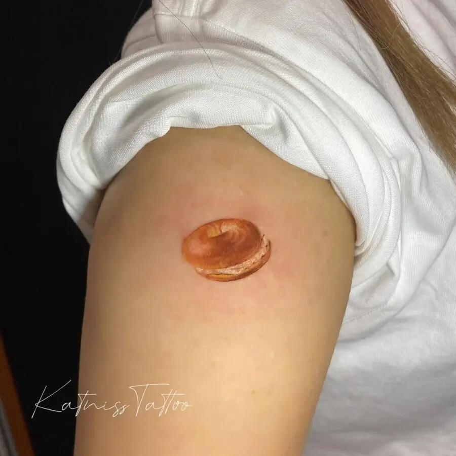 Realistic bagel tattoo on the arm