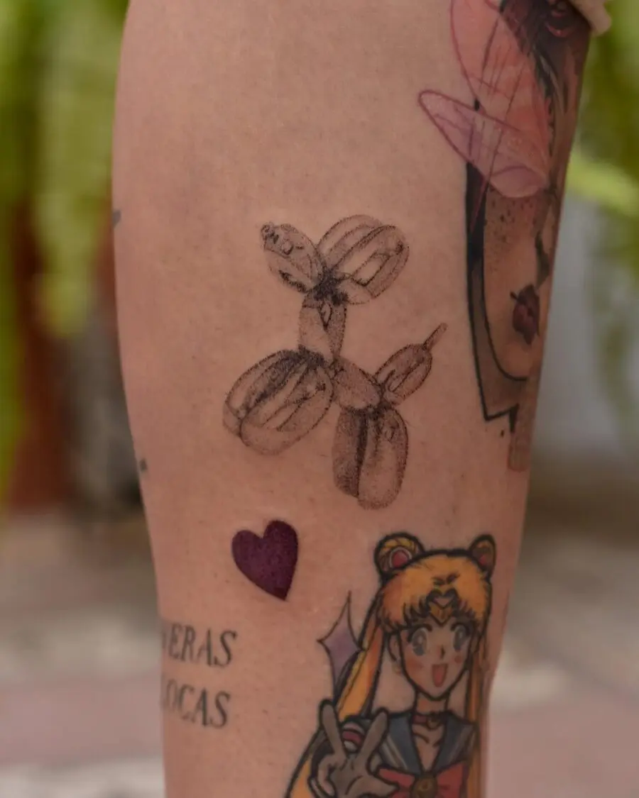 Charming balloon dog tattoo on tattooed leg