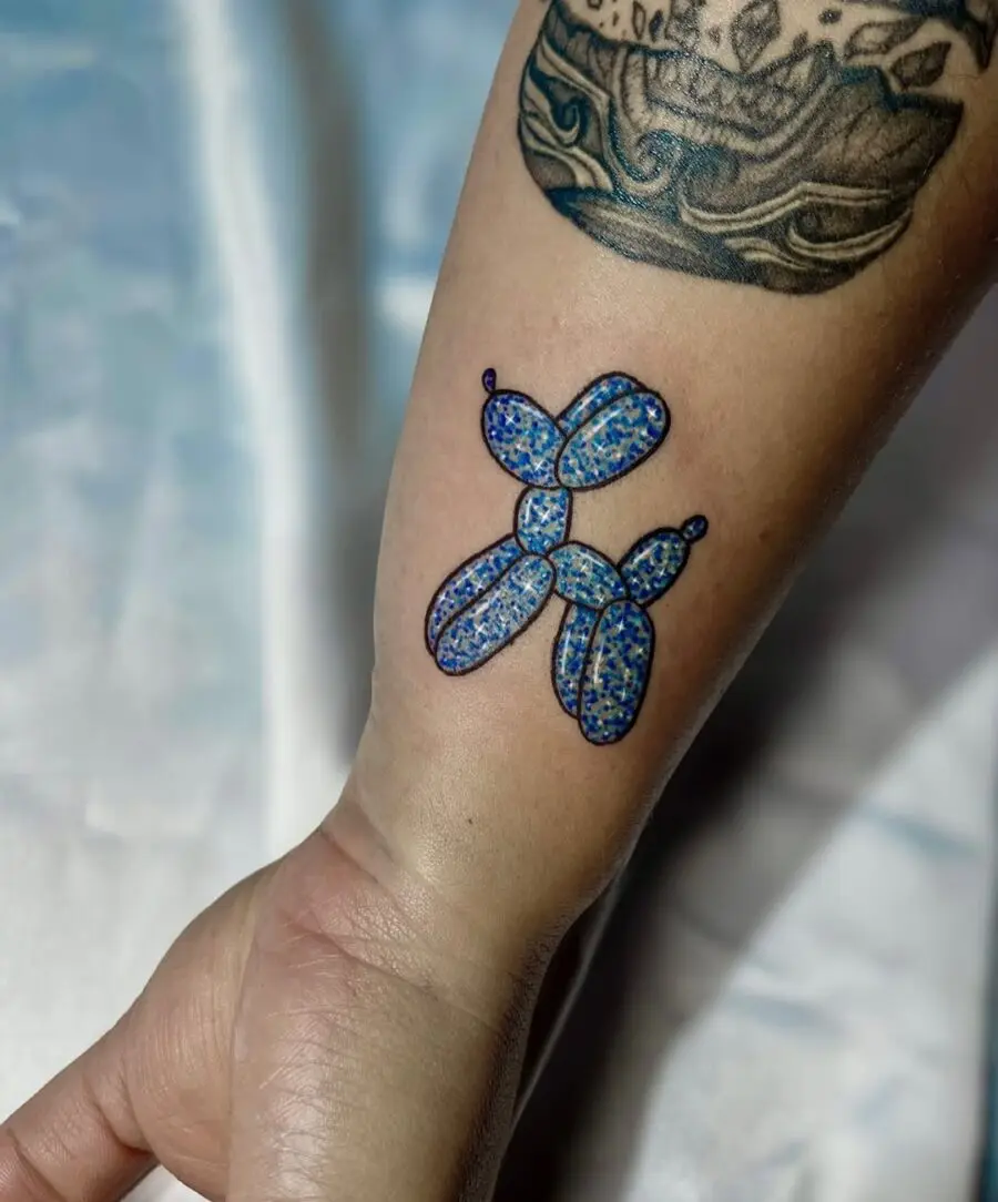 Vibrant balloon dog tattoo with glittery allure