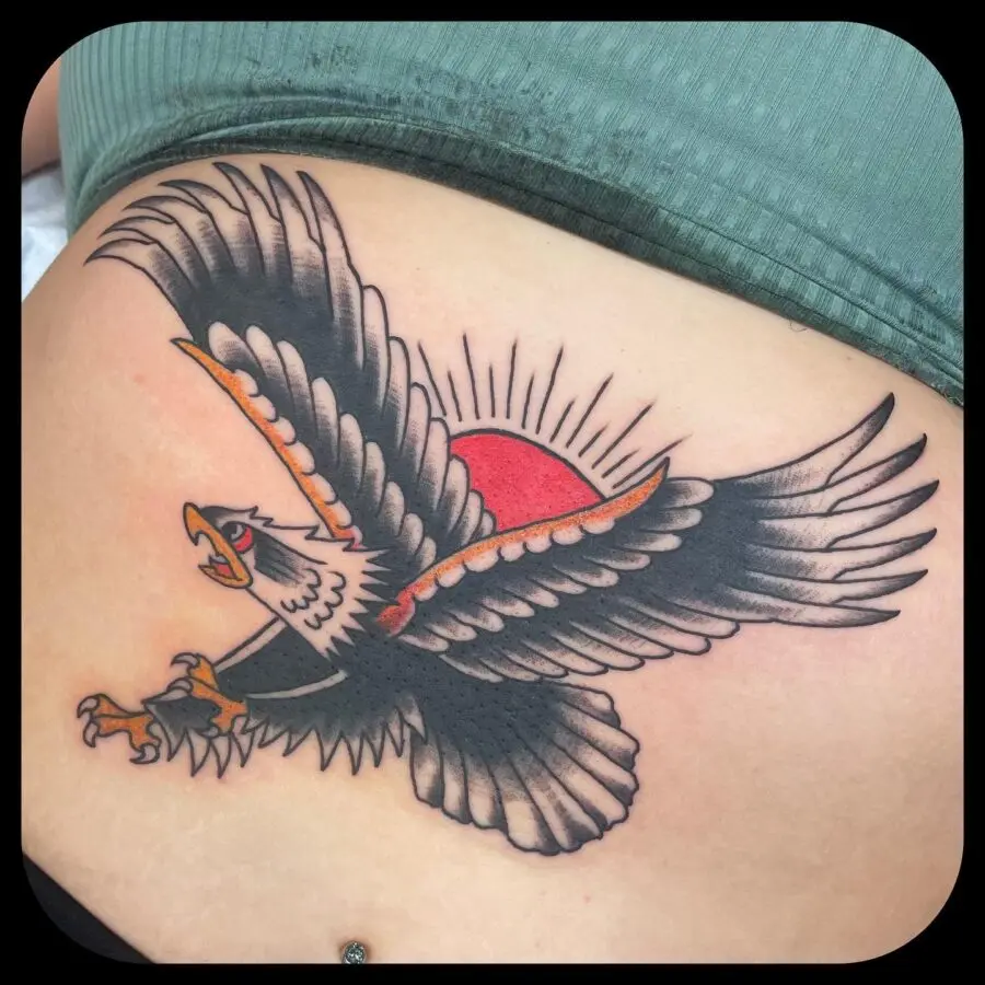 Bold eagle tattoo soaring against vibrant sunset