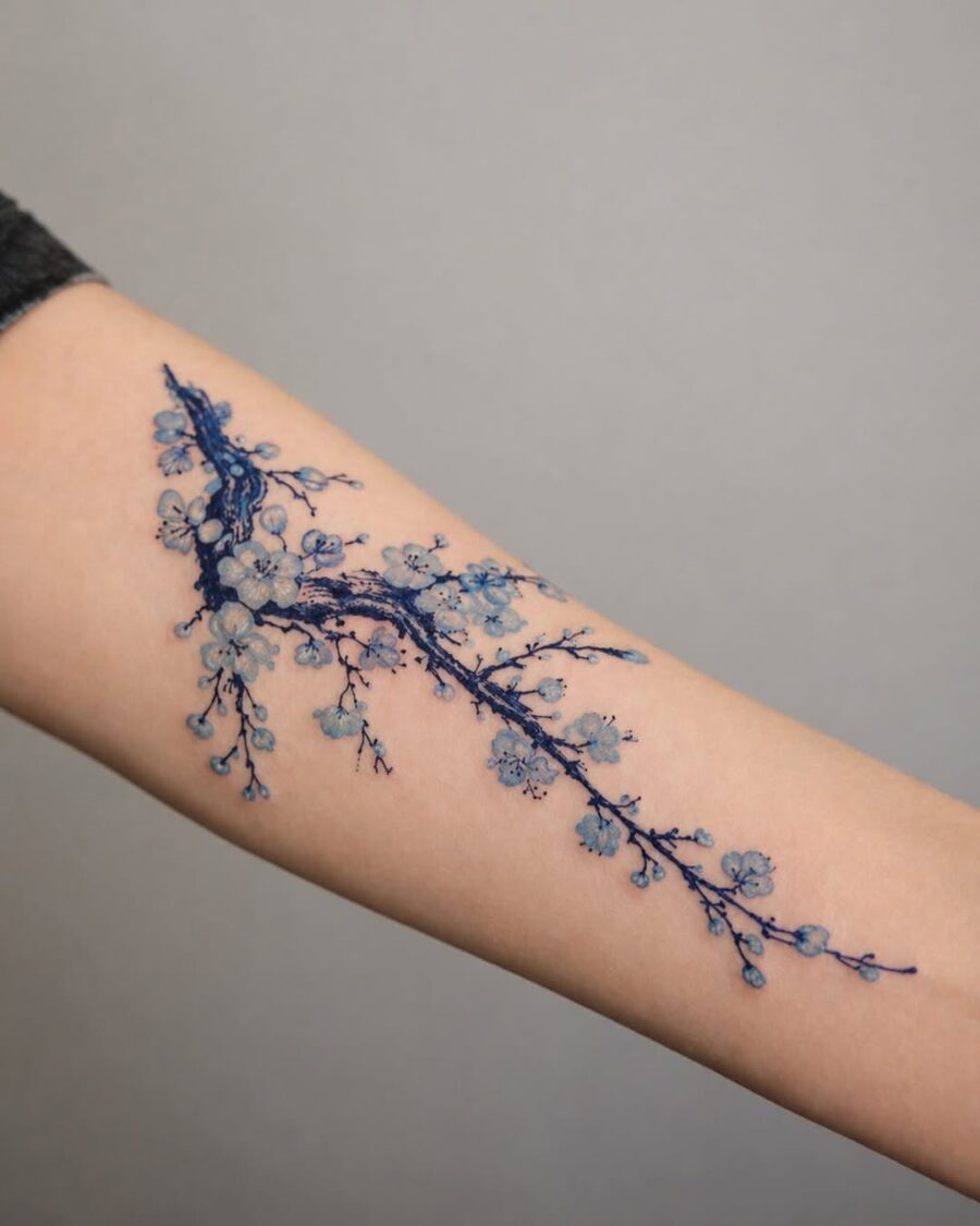 Elegant blue floral tattoo on forearm