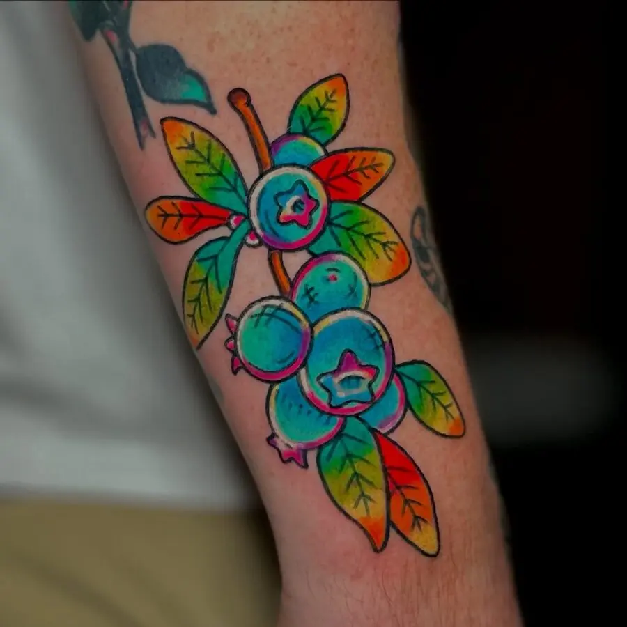 Colorful blueberry tattoo on forearm