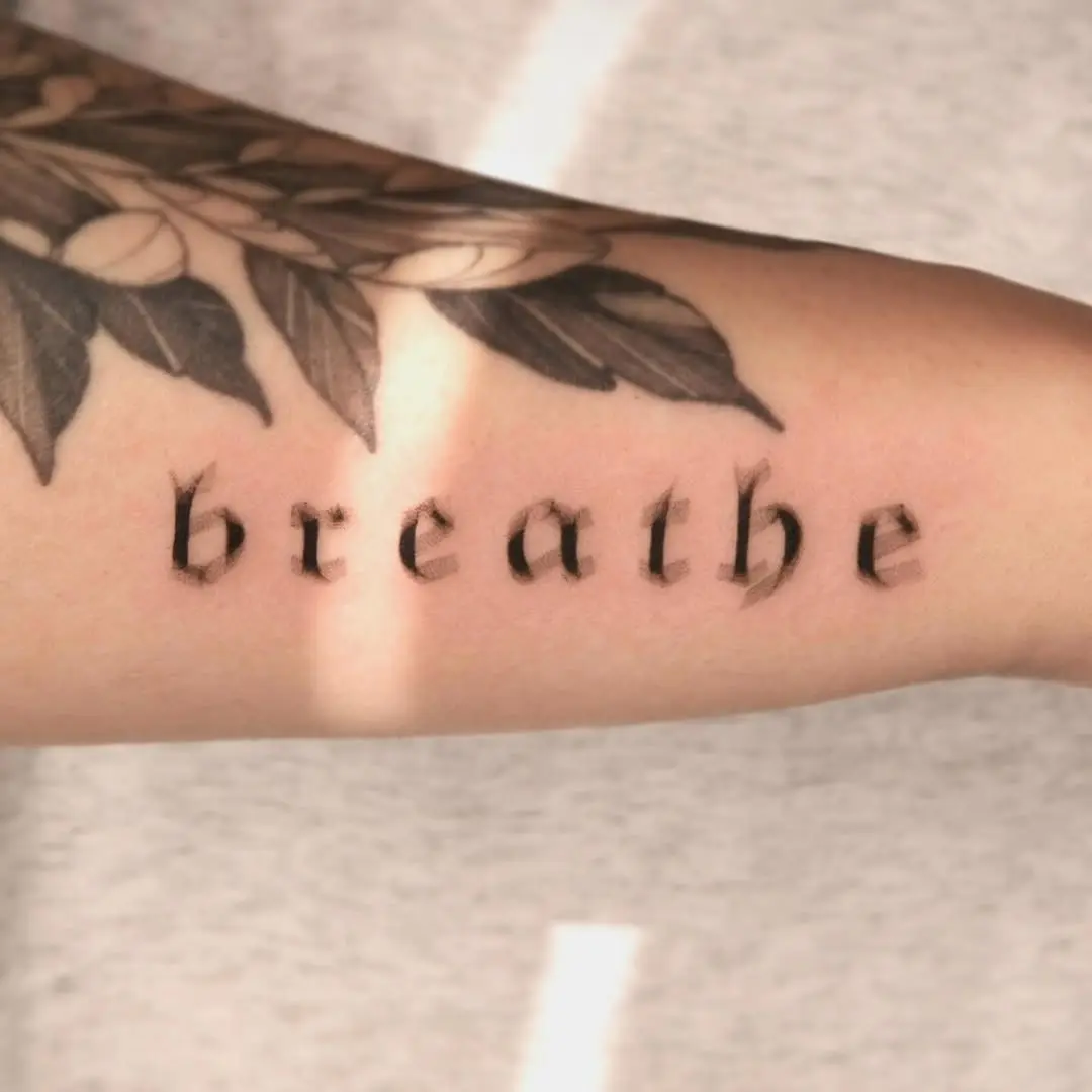 Elegant script tattoo promoting mindfulness and calmness