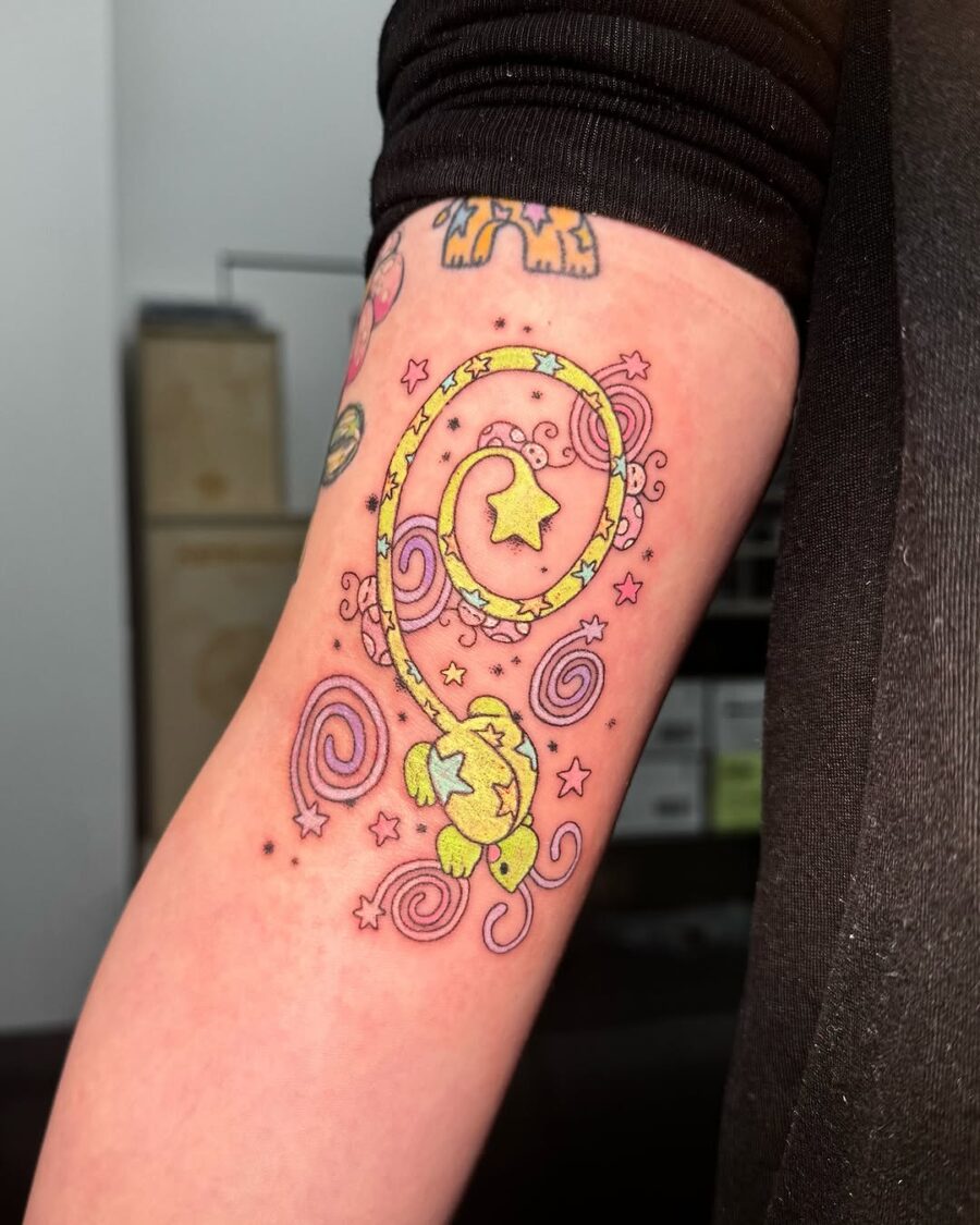 Vibrant lizard tattoo with whimsical stars.