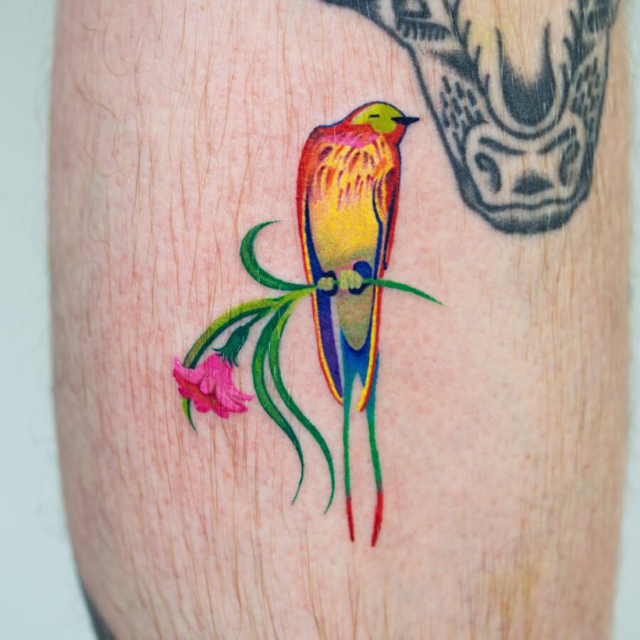 Vibrant bird tattoo with floral accents