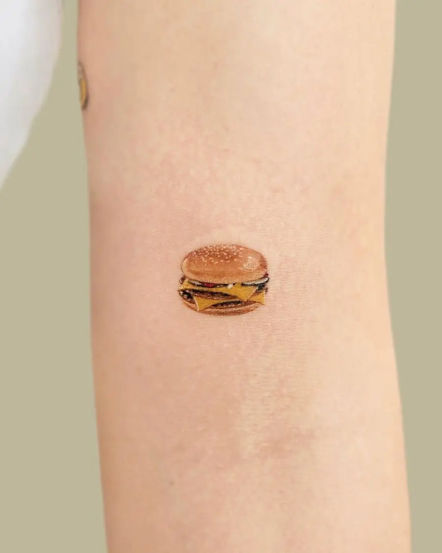 Deliciously detailed burger tattoo on forearm