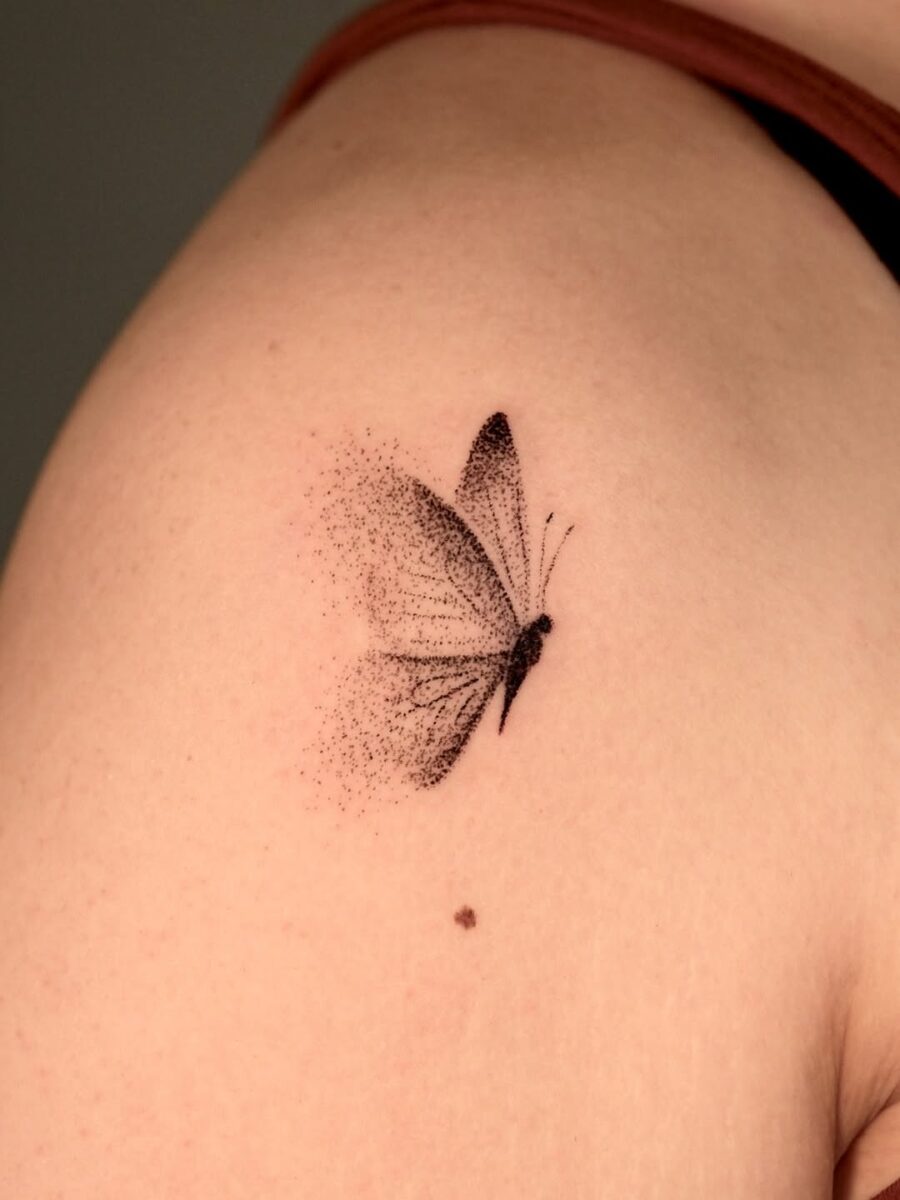 Delicate butterfly tattoo with soft black ink