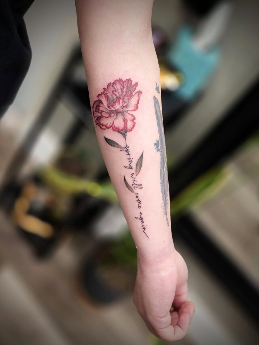 Delicate carnation tattoo on a wrist