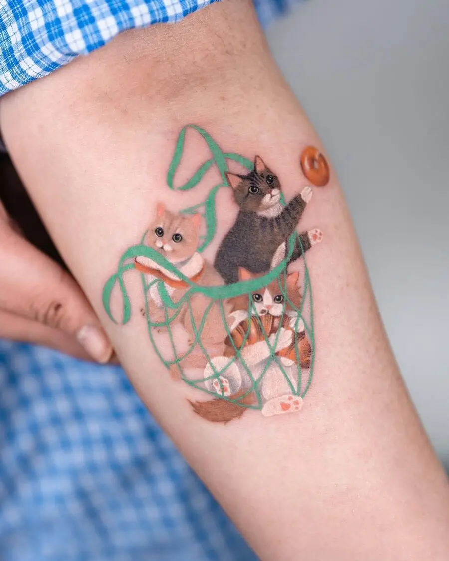 Whimsical bagel tattoo with playful cats