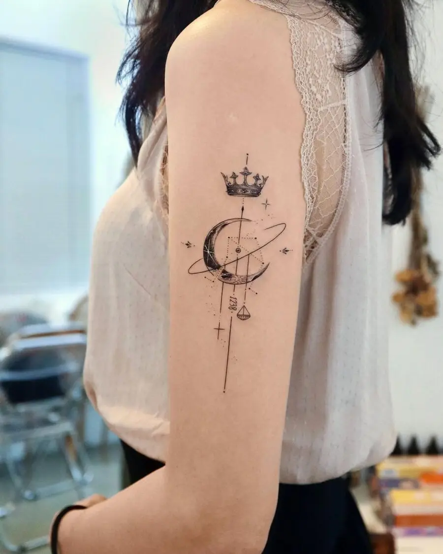 Elegant celestial tattoo featuring crown and planets