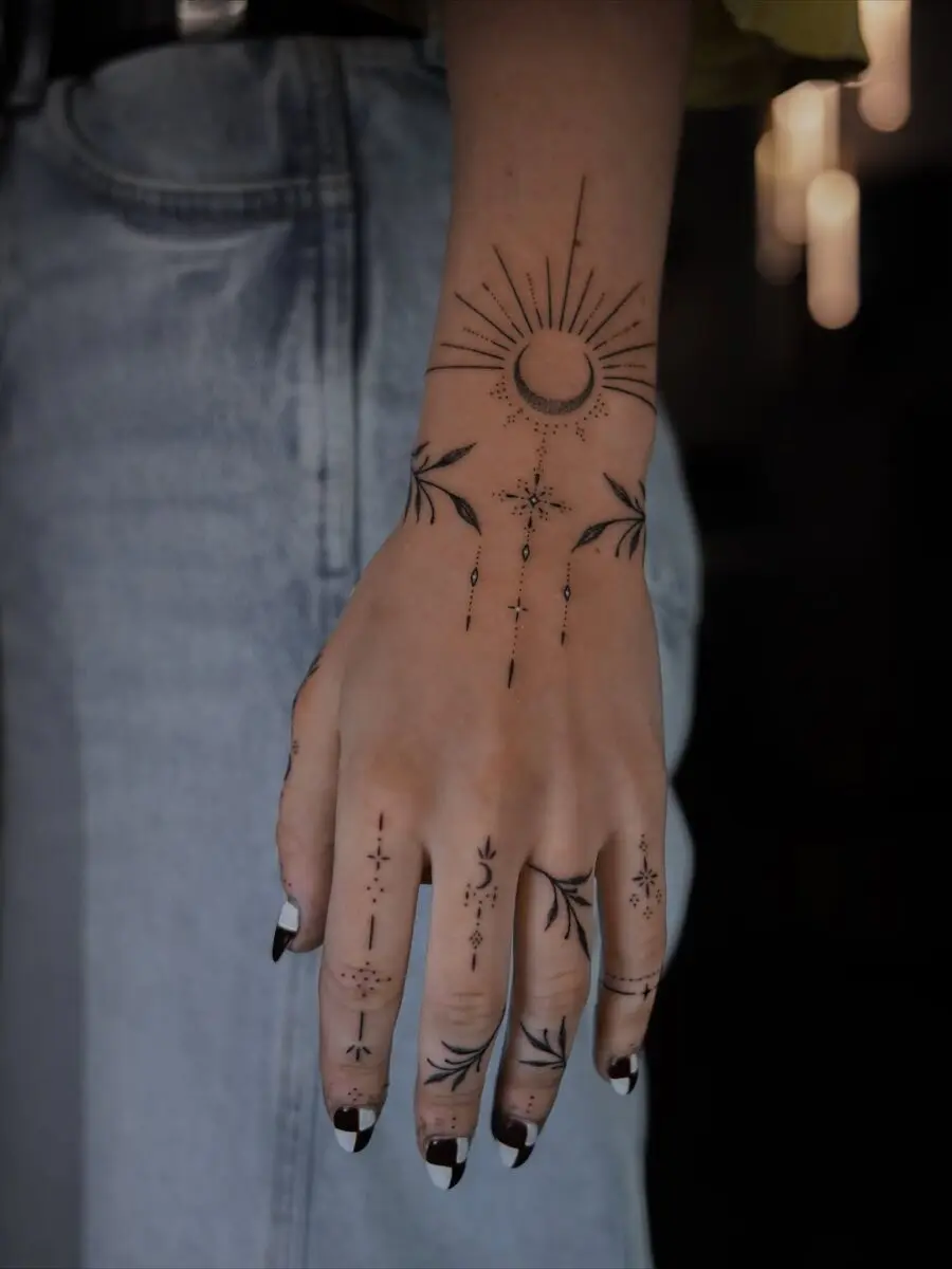 Artistic celestial tattoos adorn the hand beautifully