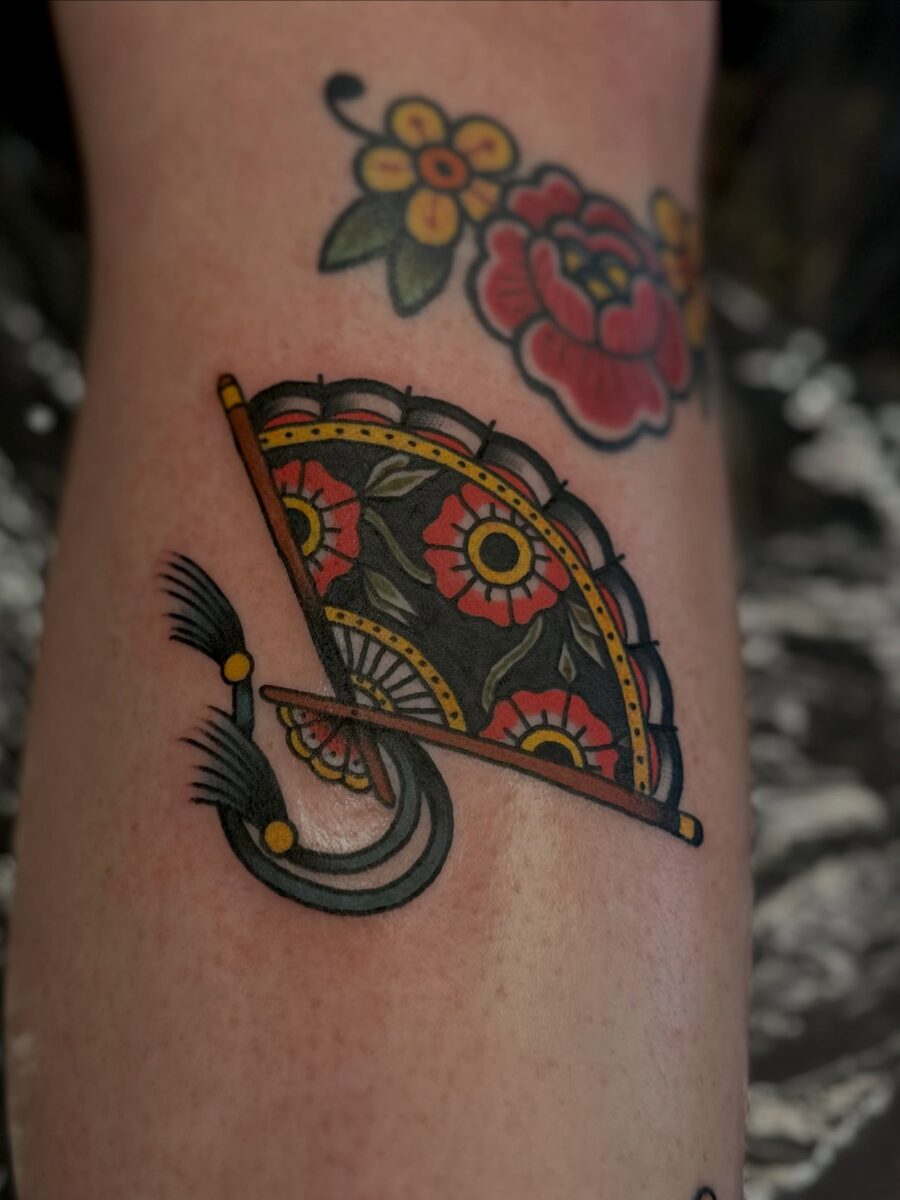 Vibrant Americana fan tattoo with floral accents