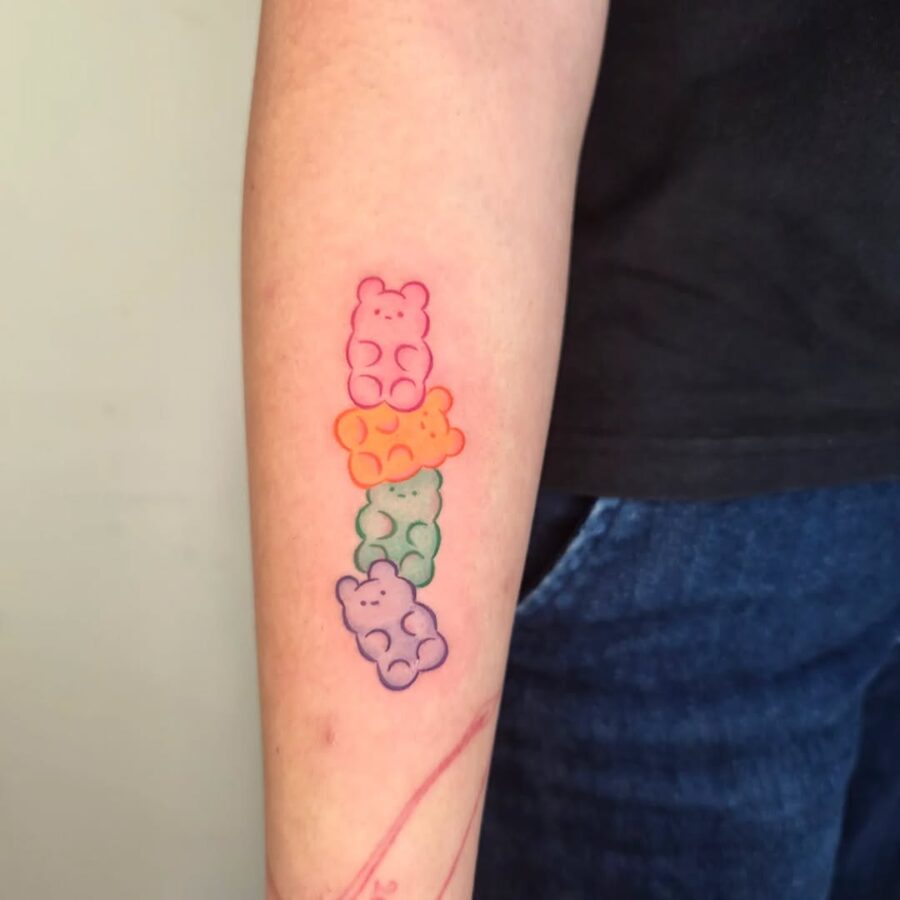 Colorful gummy bears adorned on forearm.