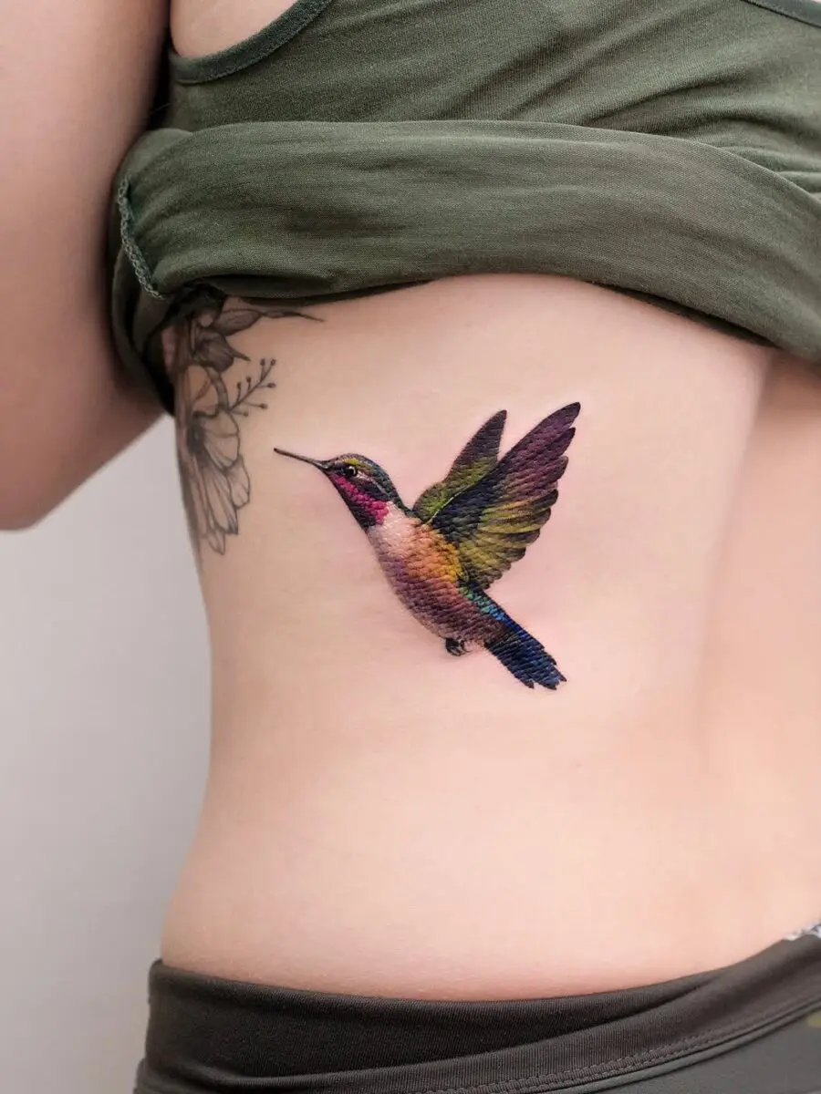 Vibrant hummingbird tattoo on the side