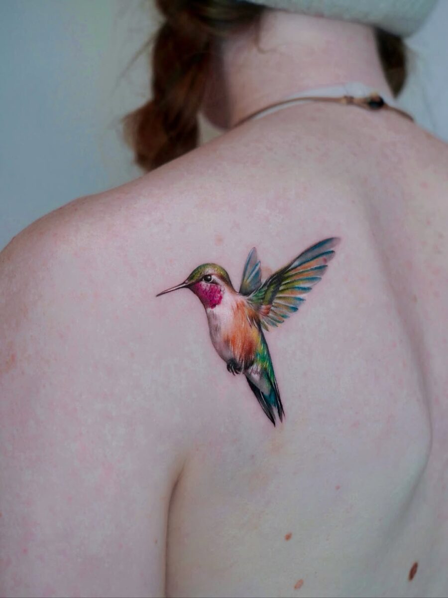A vibrant hummingbird tattoo on the shoulder
