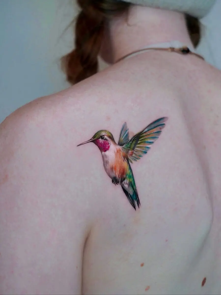 A vibrant hummingbird tattoo on the shoulder