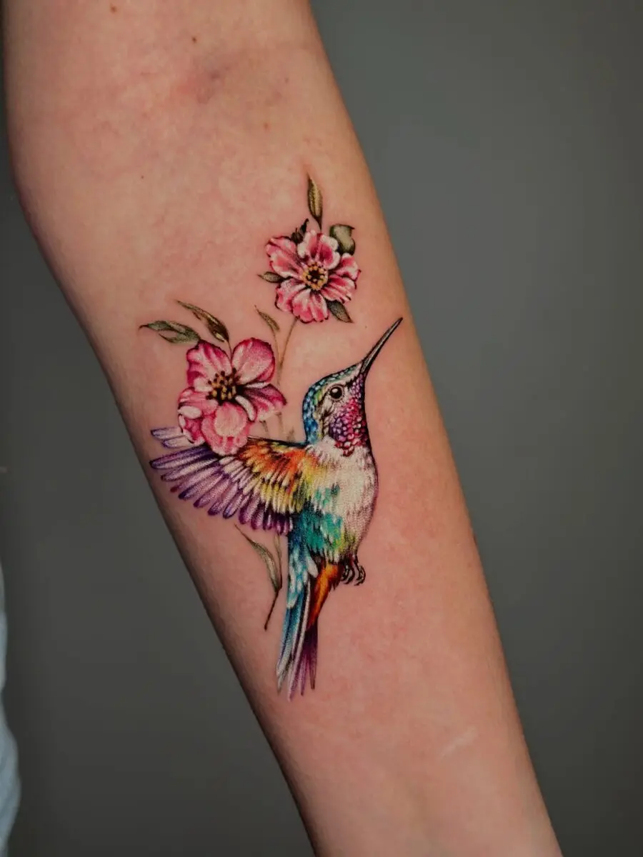 Vibrant hummingbird tattoo with floral accents
