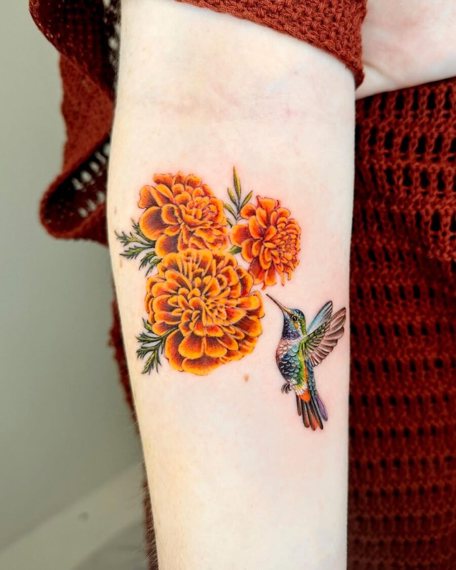 Vibrant hummingbird tattoo with marigold flowers