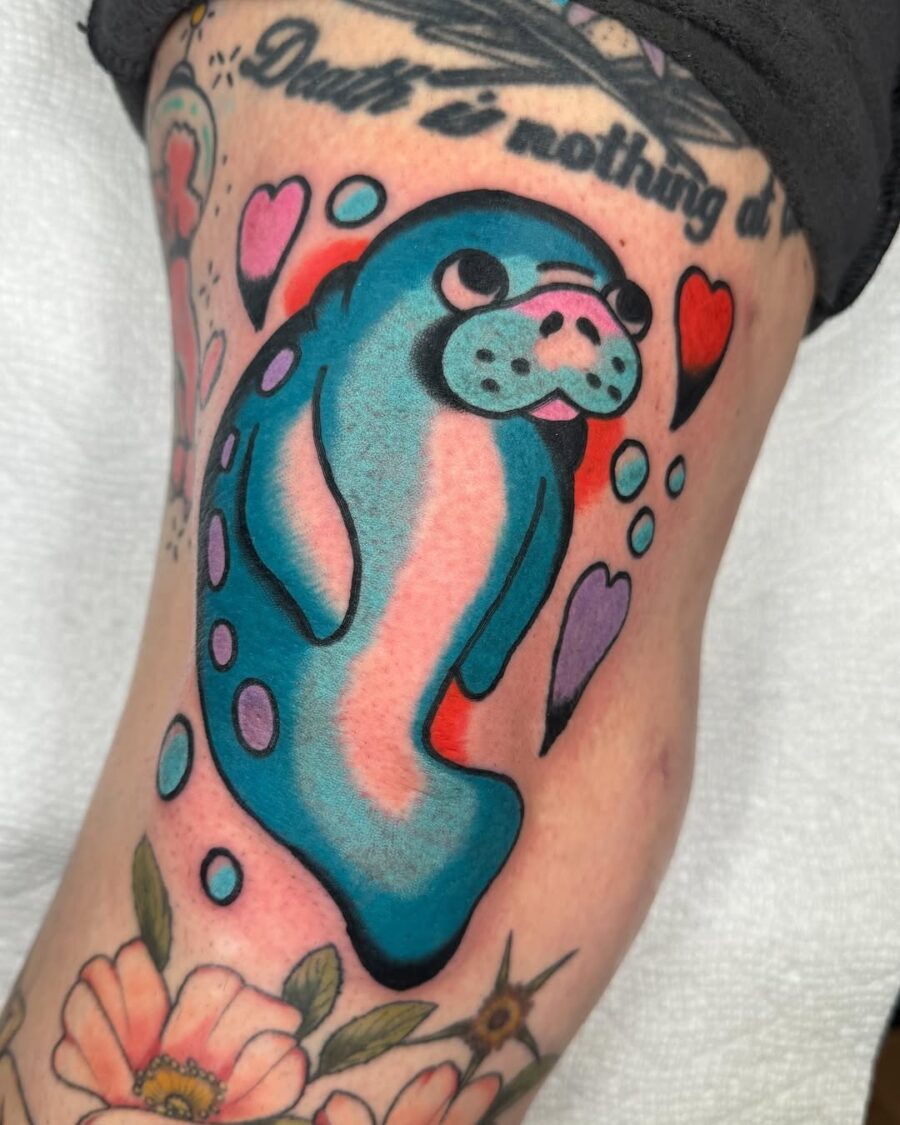Colorful manatee tattoo surrounded by hearts