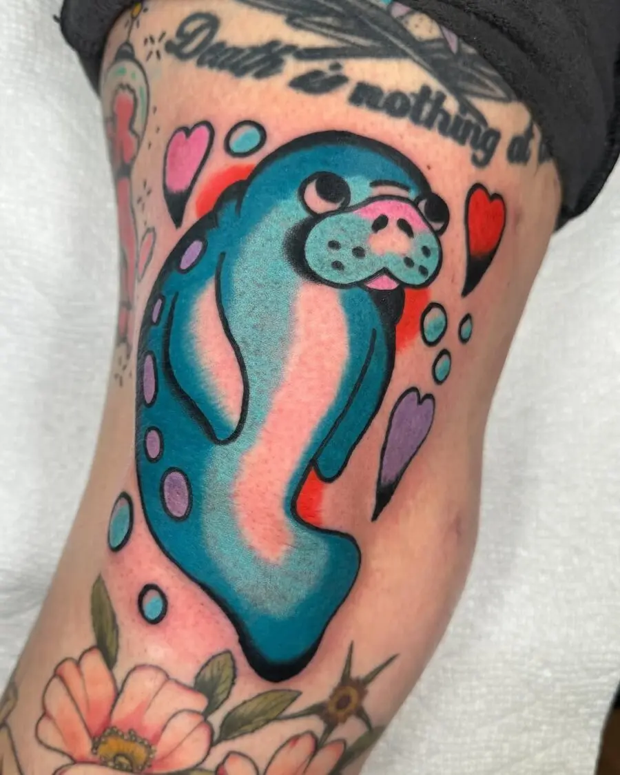 Colorful manatee tattoo surrounded by hearts