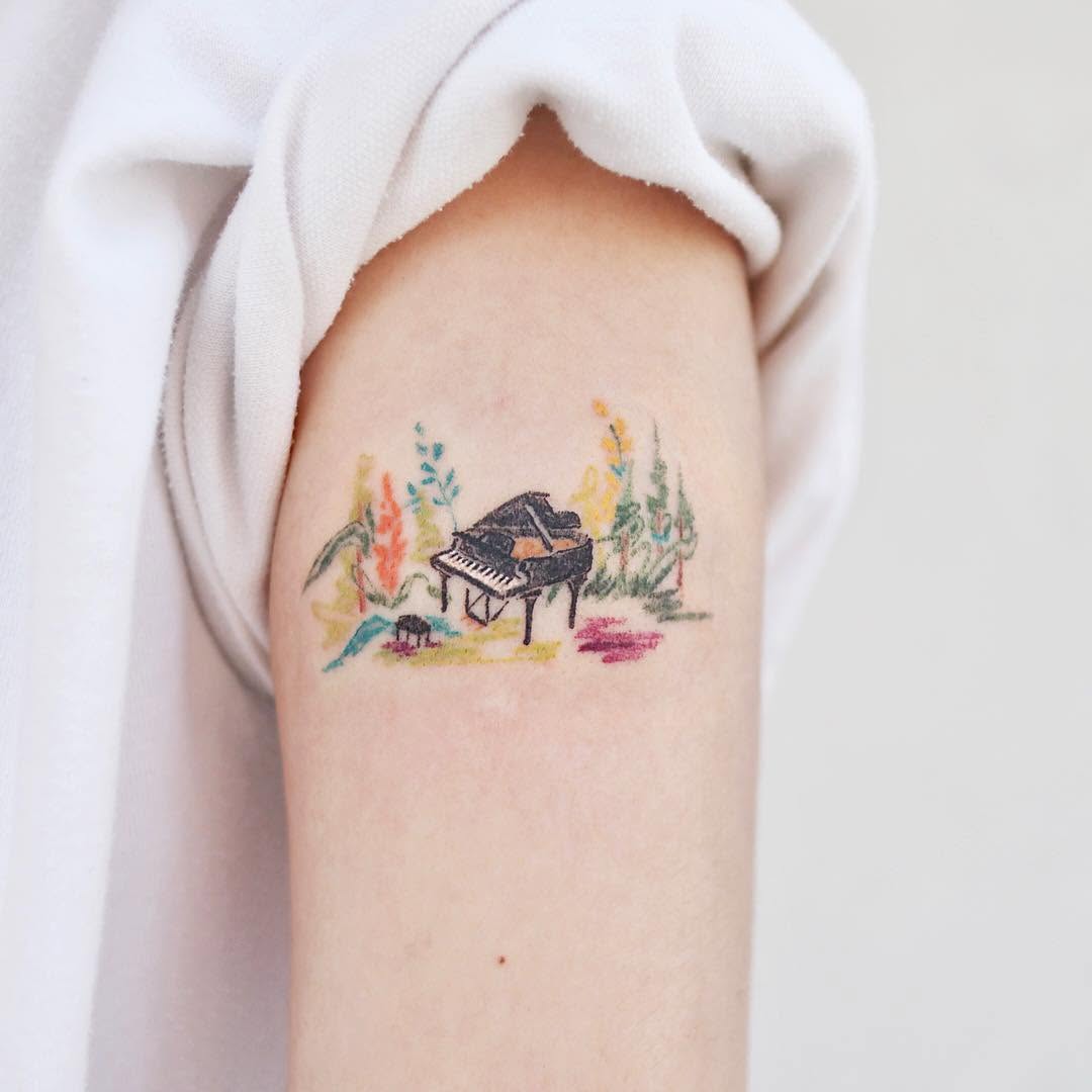 Whimsical piano tattoo with vibrant floral elements