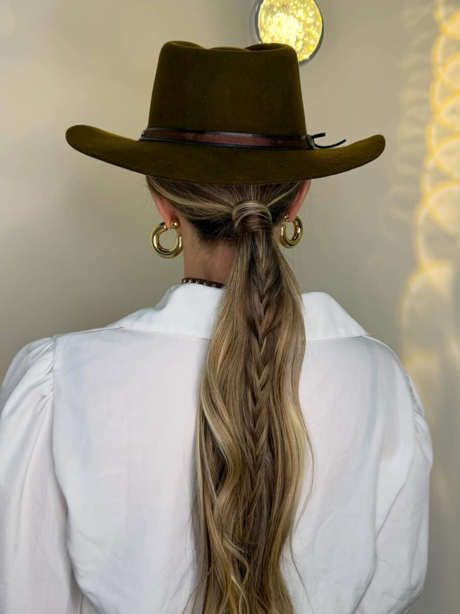 Stylish braided ponytail under a cowboy hat