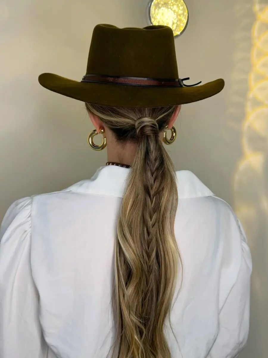 Stylish braided ponytail under a cowboy hat