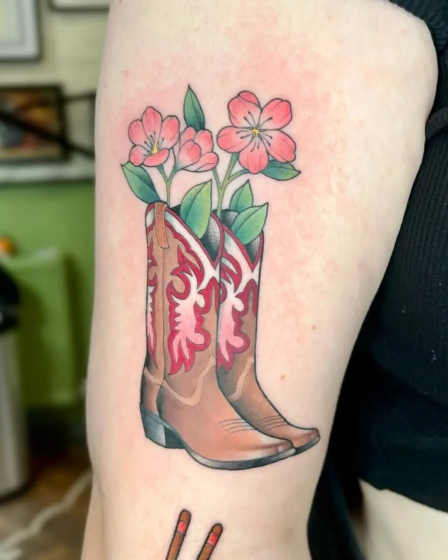 Charming tattoo featuring boots and blossoms
