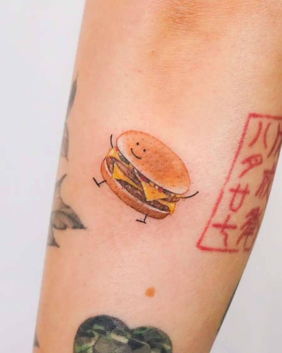 Adorable smiling burger tattoo on an arm
