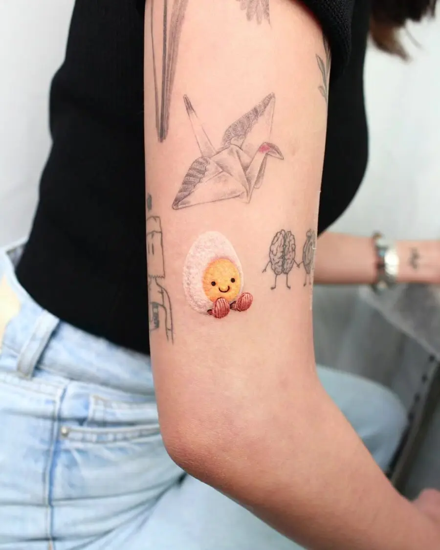 Whimsical cartoon egg tattoo in vibrant colors