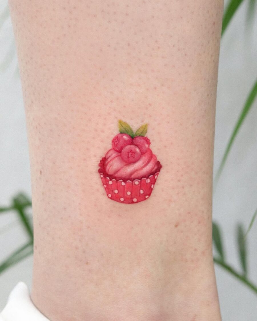 Charming pink cupcake tattoo with red accents