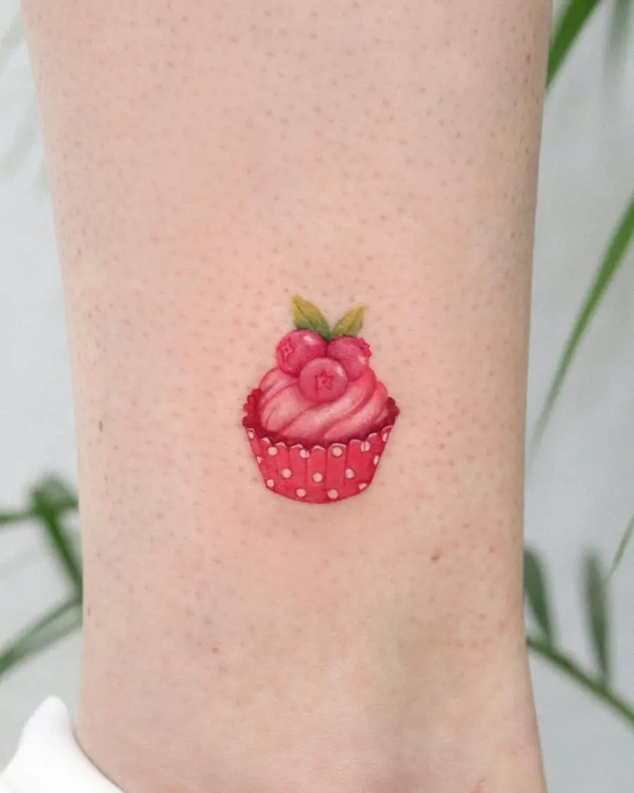 Charming pink cupcake tattoo with red accents