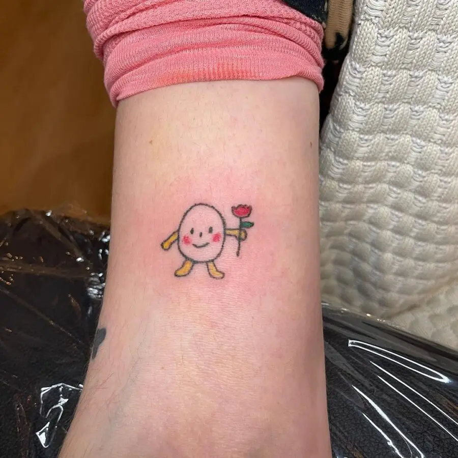 Charming egg character holding a flower tattoo