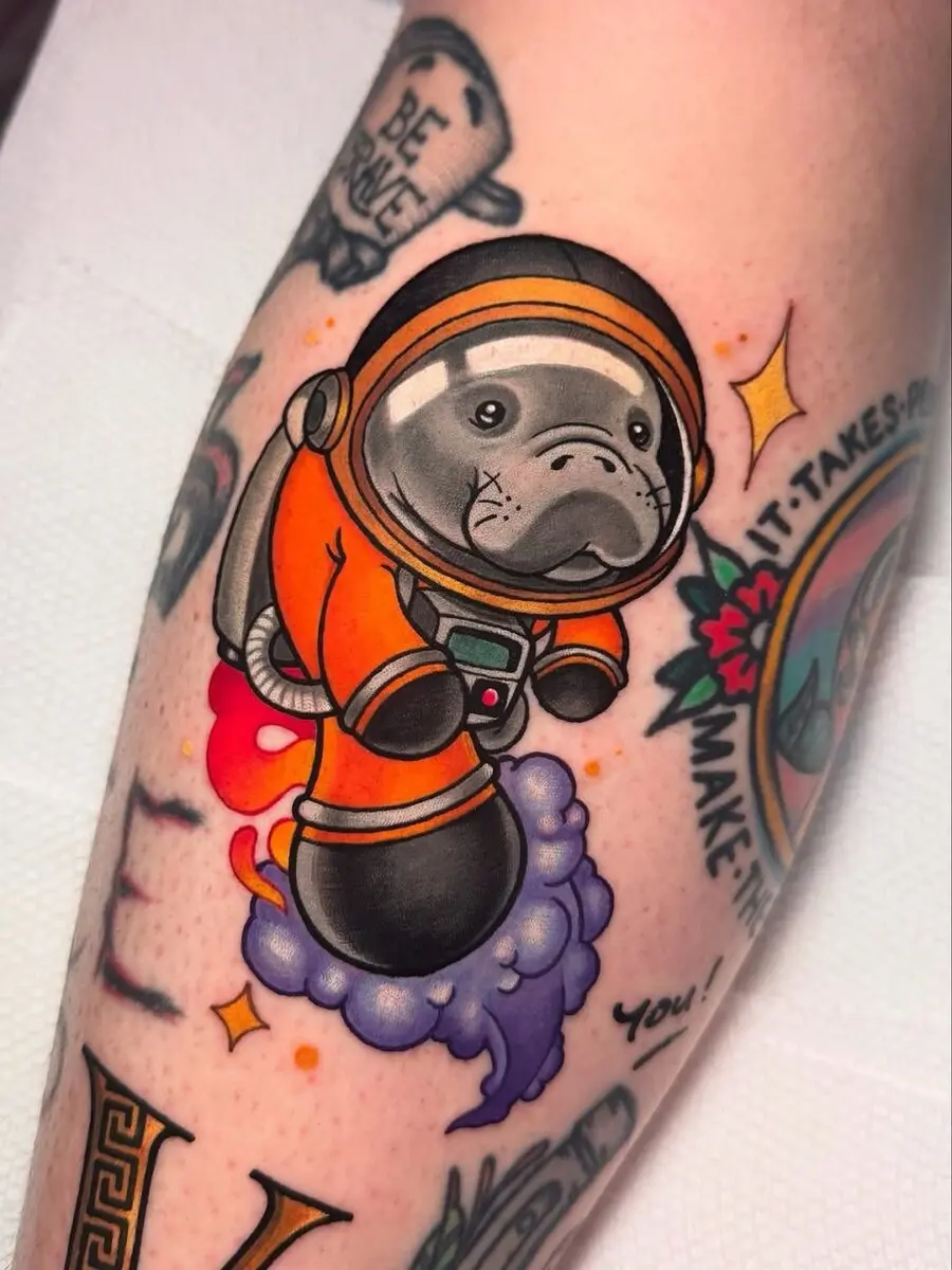 Adorable astronaut manatee tattoo in vibrant colors