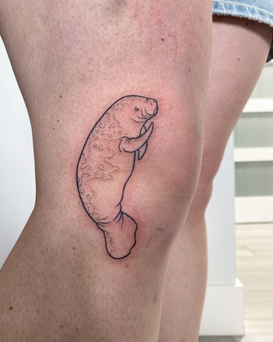 Charming and playful manatee thigh tattoo design